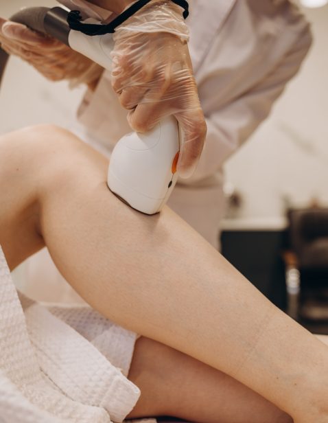 master makes the girl's legs a laser hair removal procedure